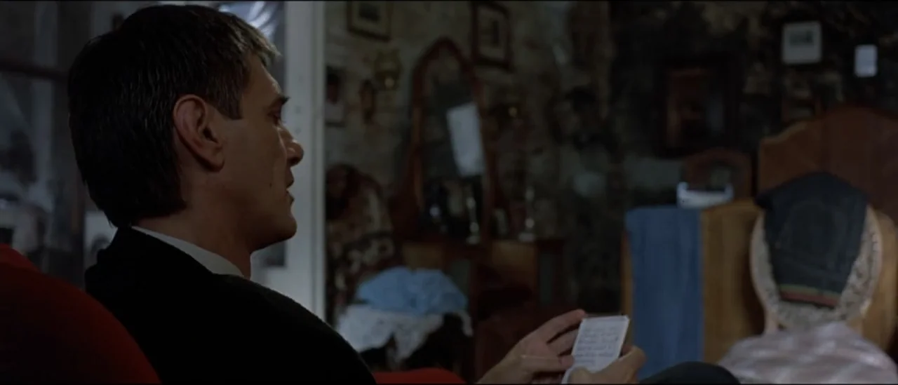 The Peacemaker (1997) movie still: medium — A cluttered, dimly lit bedroom contains antique furniture, framed pictures, and personal trinkets. A…