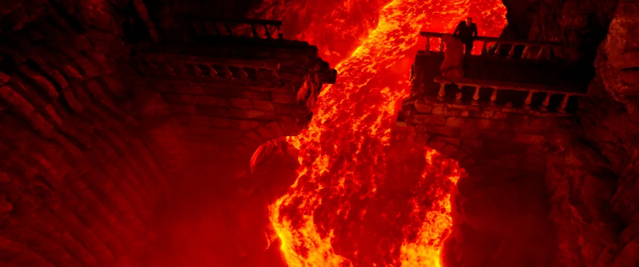 The House That Jack Built (2018) movie still: wide — A crumbling stone bridge stretches across a deep crevice filled with molten lava. The dark…