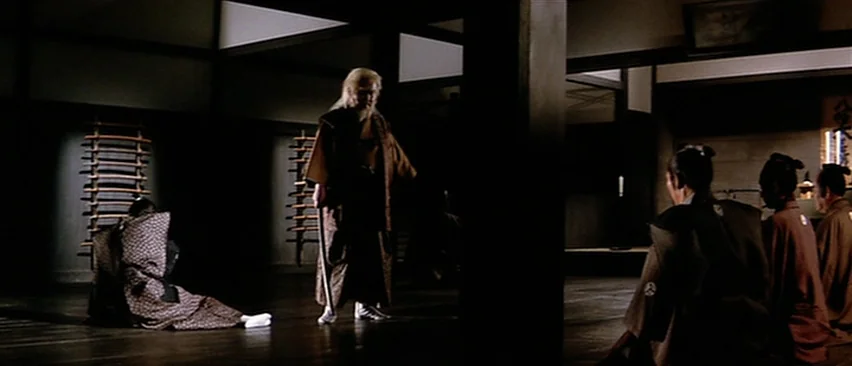 Lone Wolf and Cub: Baby Cart in Peril (1972) movie still: wide — A spacious room with dark wooden pillars and walls displaying mounted wooden…