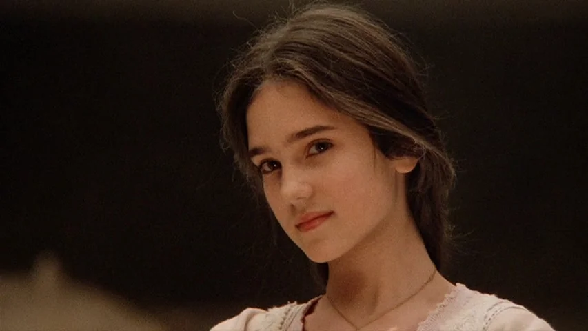 Once Upon A Time In America (1984) movie still: closeup — A teenager stands against an out-of-focus background in an open outdoor area. She faces…