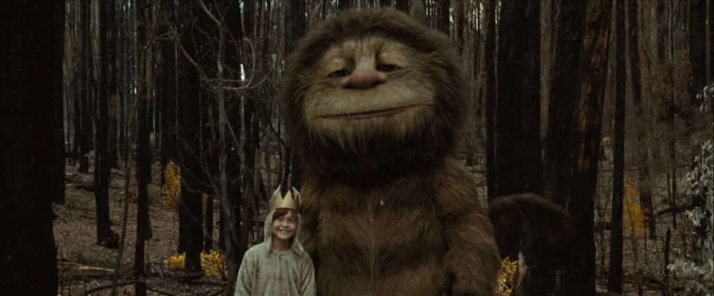 Where The Wild Things Are (2009) movie still: medium — A dark, charred forest filled with thin, soot-covered trunks and scattered yellow underbrush.…