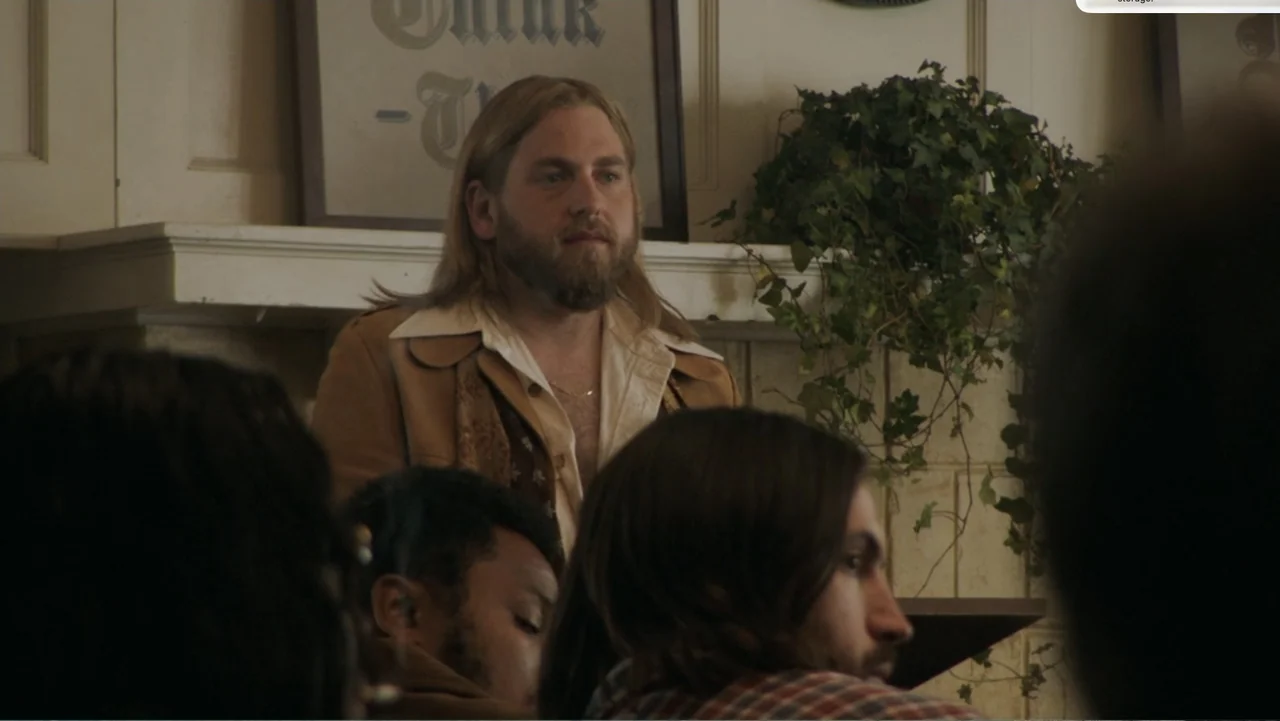 Don't Worry, He Won't Get Far on Foot (2018) movie still: medium — An interior space features a cream-colored fireplace mantle adorned with a…