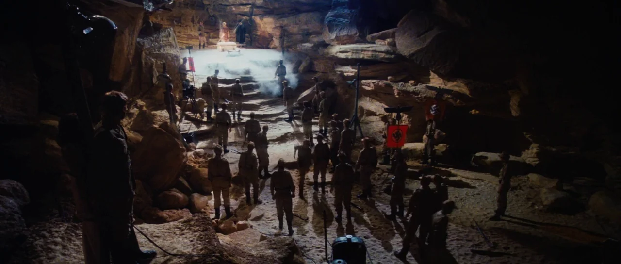 Raiders Of The Lost Ark (1981) movie still: wide — A subterranean sandstone chamber contains an elevated platform surrounded by many soldiers in…