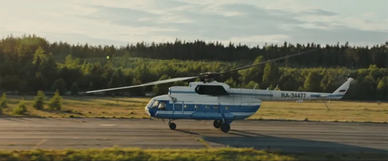 In the Line of Duty: Smoke Jumpers (1996) movie still: wide — An asphalt runway stretches past a dense green pine forest under a clear sky. A blue…