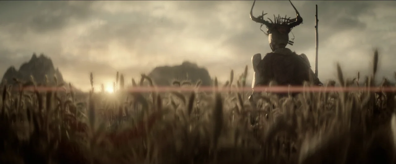 Rebel Moon – Part One: A Child of Fire (2023) movie still: medium — A vast field of wheat stretches toward distant mountains under a cloudy, sunset…
