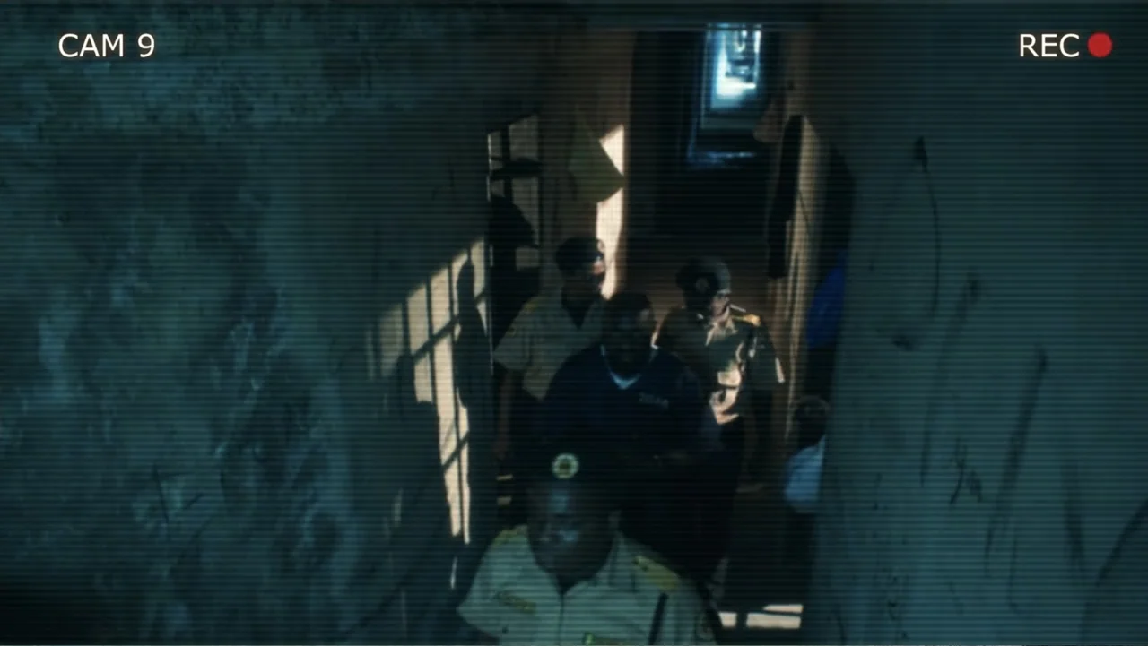 SIN: Blackout (2025) movie still: medium — A narrow, dimly lit concrete stairwell features rough walls and a descending flight of stairs. Three…
