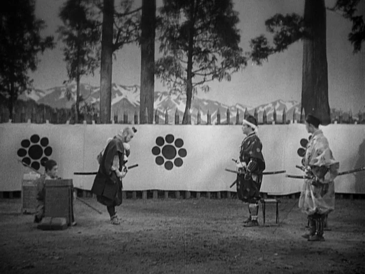 The Men Who Tread on the Tigers Tail (1945) movie still: wide — An open field features tall trees and distant snowy mountains behind a white banner.…