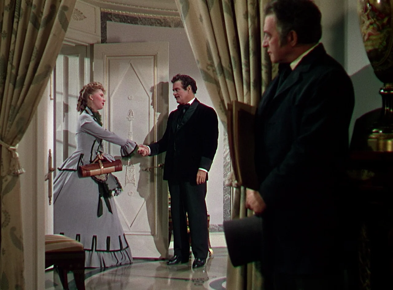 Phantom of the Opera (1943) movie still: fullbody — An elegant corridor with patterned curtains and marble-like flooring connects two rooms. A woman…