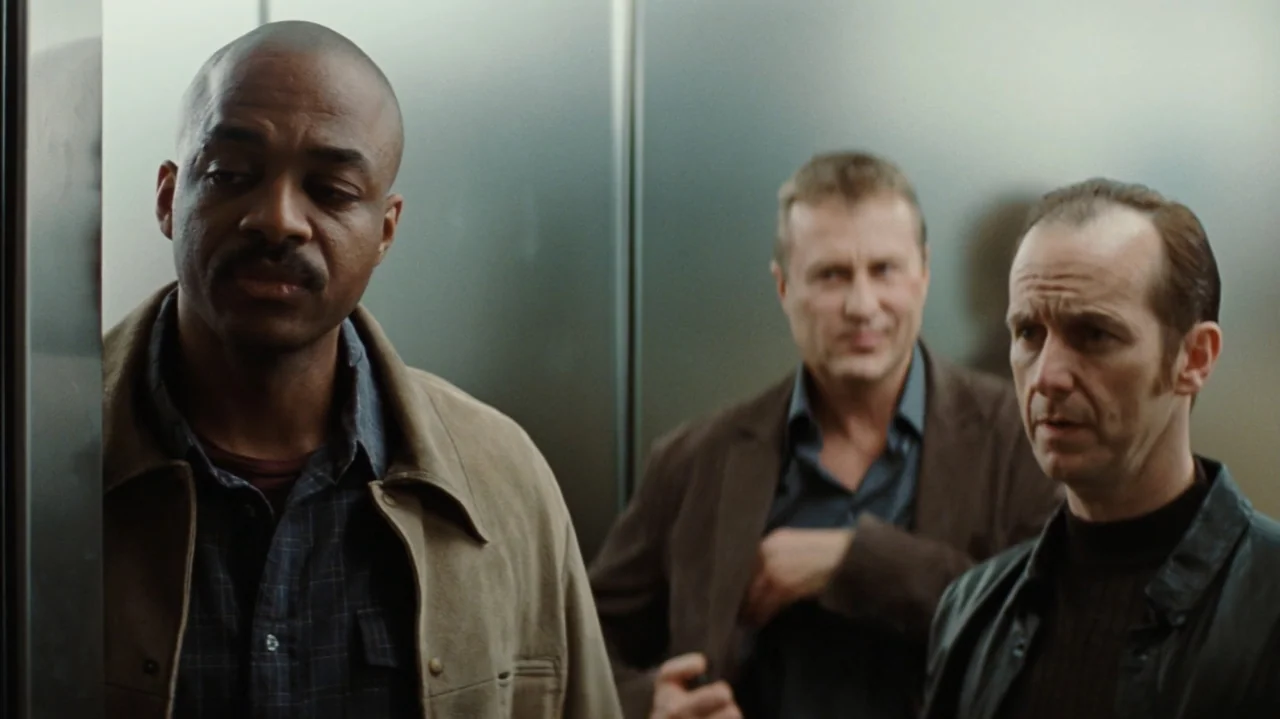 Duplicity (2009) movie still: medium — Three men stand side-by-side within the metallic enclosure of an elevator. They face slightly away from each…