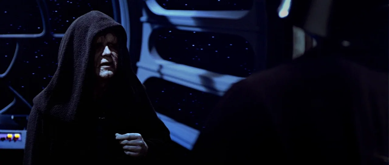 Return Of The Jedi (1983) movie still: medium — A dark spaceship interior features a large viewport showing distant stars in deep space. An elderly…