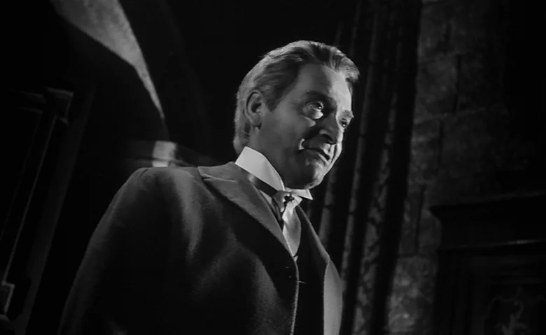Black Sunday (1960) movie still: medium — A stone interior with dark shadows and heavy masonry in a formal setting. The man stands in the…