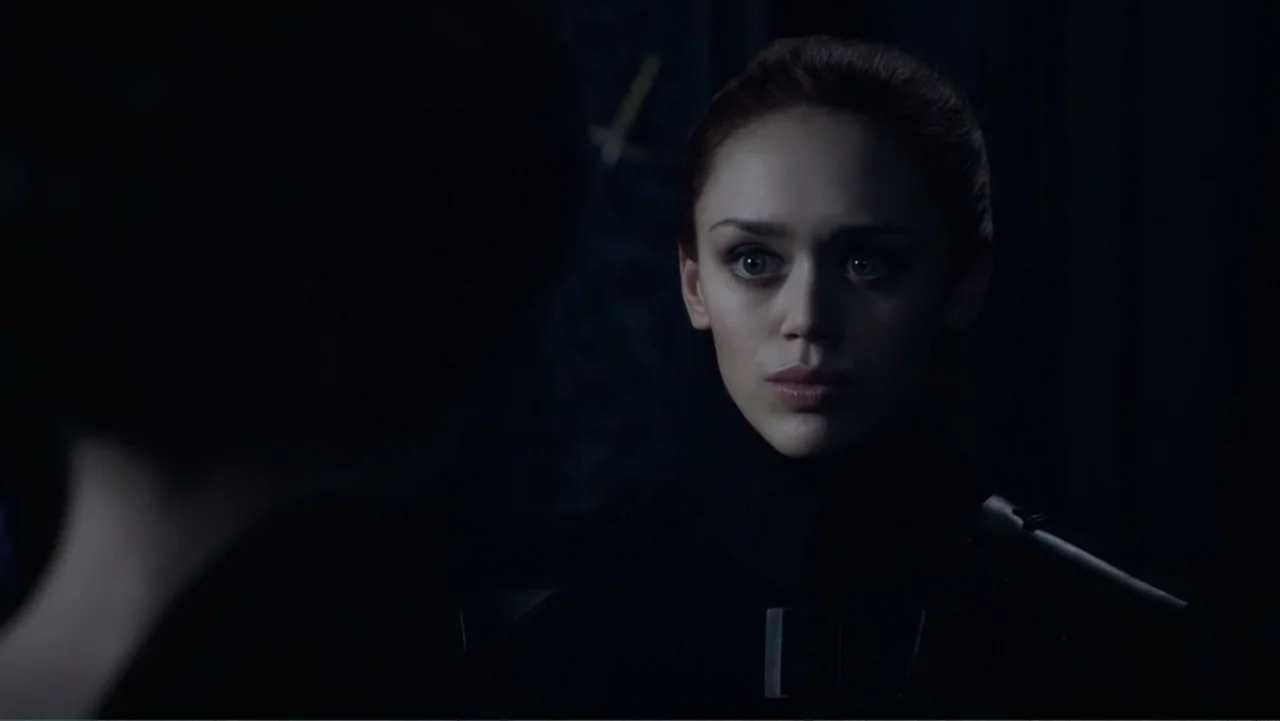Underworld: Blood Wars (2016) movie still: closeup — A dark indoor setting with minimal detail visible behind the central subject. A young woman…