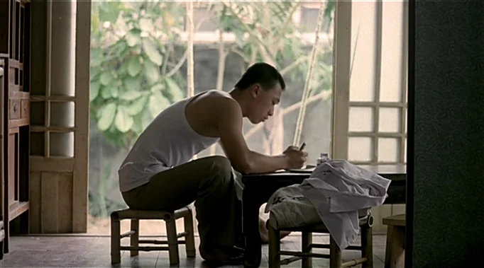 A Time To Love and A Time To Die (1985) movie still: medium — A traditional wooden structure features an open frame overlooking a blurred outdoor…