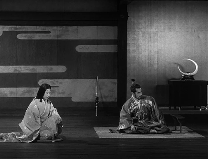 Throne of Blood (1957) movie still: wide — A spacious room features minimalist wood flooring and traditional screen walls with painted designs. A…