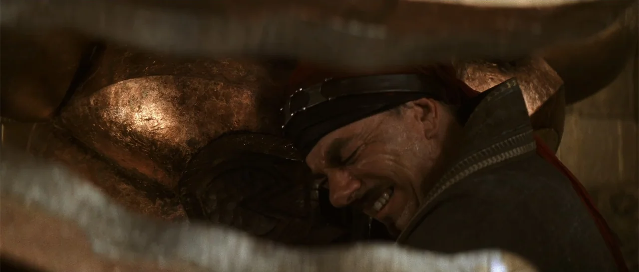 The Mummy Returns (2001) movie still: closeup — An interior space features metallic textures and dark, stone-like surroundings in a dim environment.…
