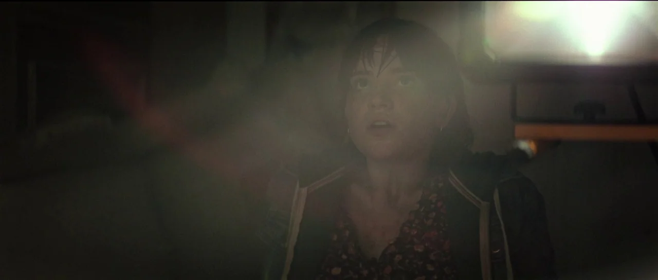 The Boogeyman (2023) movie still: closeup — A dark indoor environment featuring a person illuminated by a bright rectangular light source. The…
