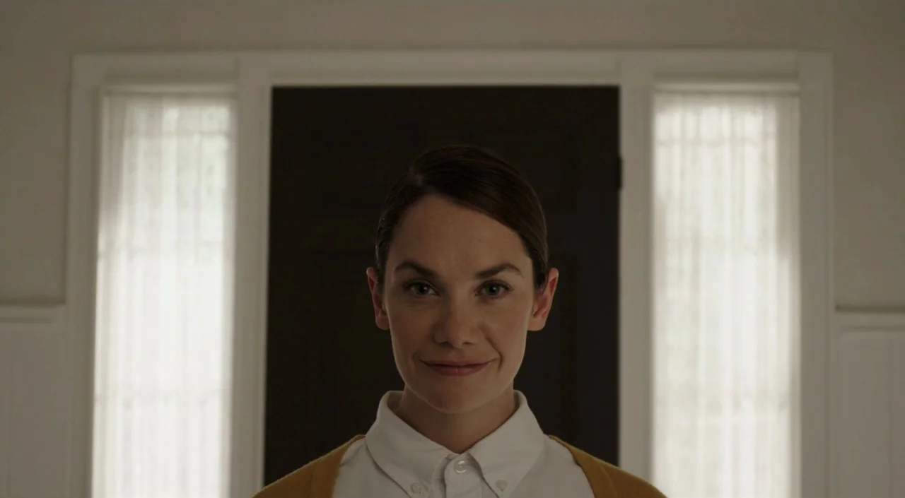 I Am The Pretty Thing That Lives In The House (2016) movie still: closeup — An interior entryway features a dark wooden door flanked by white panels…