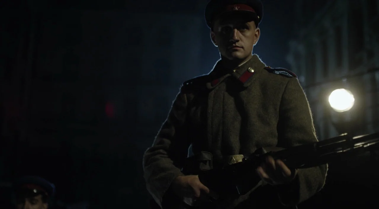 The Death of Stalin (2017) movie still: medium — A nighttime city street serves as the setting for a soldier in period uniform. The soldier holds a…