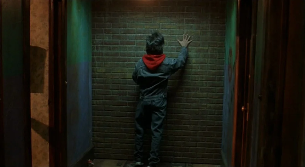 Freddy’s Dead: The Final Nightmare (1991) movie still: fullbody — A narrow hallway with a brick end-wall features painted green and purple sections.…