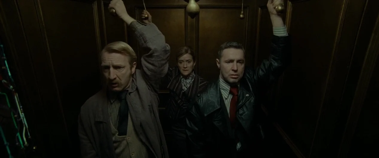 Harry Potter & The Deathly Hallows Part 1 (2010) movie still: medium — Three people stand inside a dark, paneled wooden elevator carriage with brass…