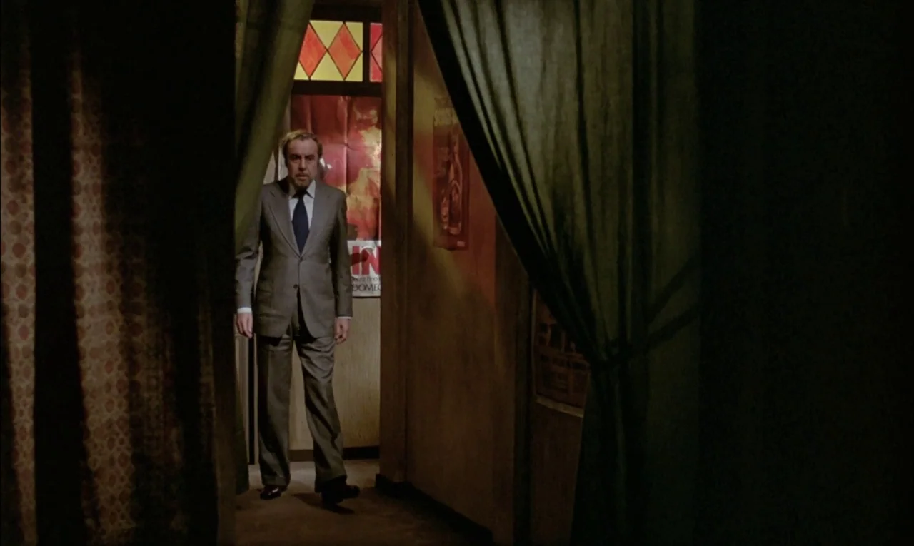 That Obscure Object of Desire (1977) movie still: fullbody — A dimly lit corridor features dark curtains framing the entrance to a secondary room. A…