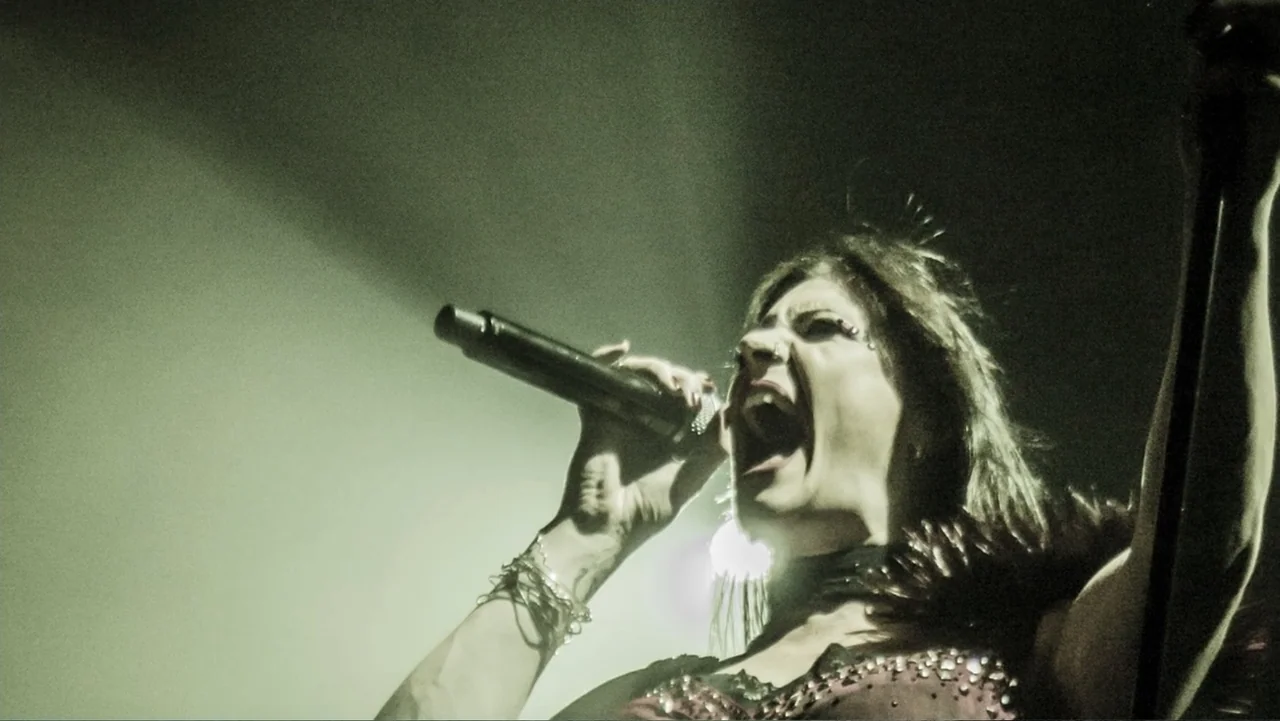 Soaring Highs and Brutal Lows: The Voices of Women in Metal (2015) movie still: closeup — A dimly lit live performance space is dominated by a…