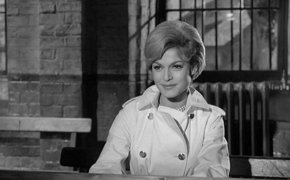 The Criminal (1960) movie still: medium — A room with brick walls and barred windows suggesting a secured facility environment. A woman with a…