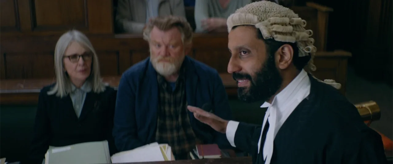 Hampstead (2017) movie still: medium — A wood-paneled courtroom features rows of dark benches and legal documents on tables. A barrister in a wig…