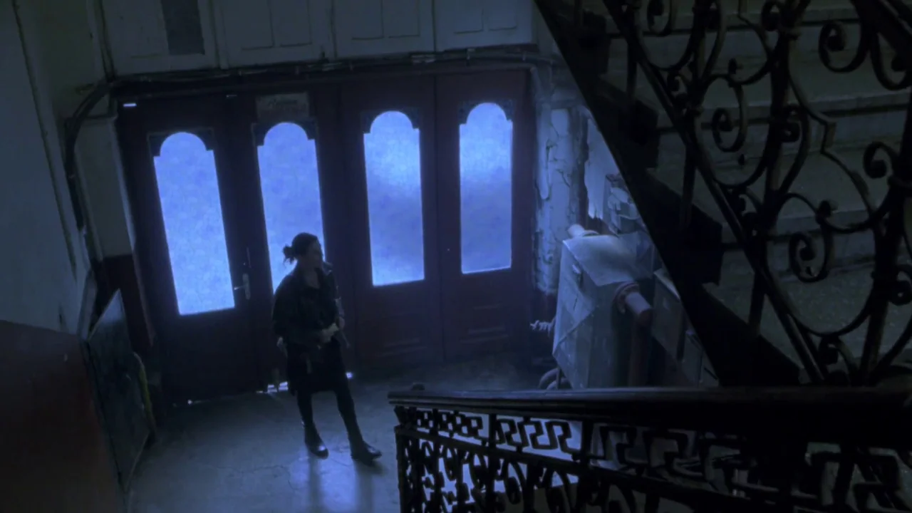 Hellraiser: Deader (2005) movie still: wide — A dimly lit apartment building stairwell features ornate metal railings and worn plaster walls. A…