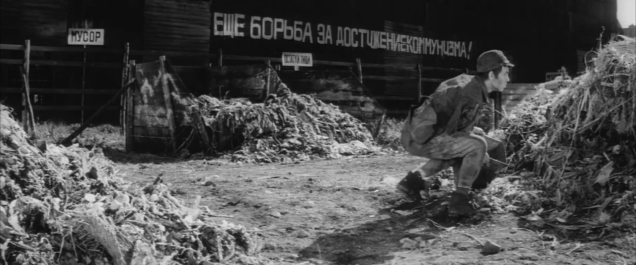 The Human Condition III: A Soldier’s Prayer (1961) movie still: medium — A rural dumping ground featuring large mounds of organic waste and Soviet…