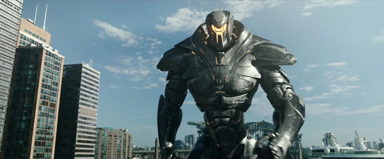 Pacific Rim: Uprising (2018) movie still: fullbody — A massive metallic humanoid robot walks through a modern urban harbor area by skyscrapers. The…