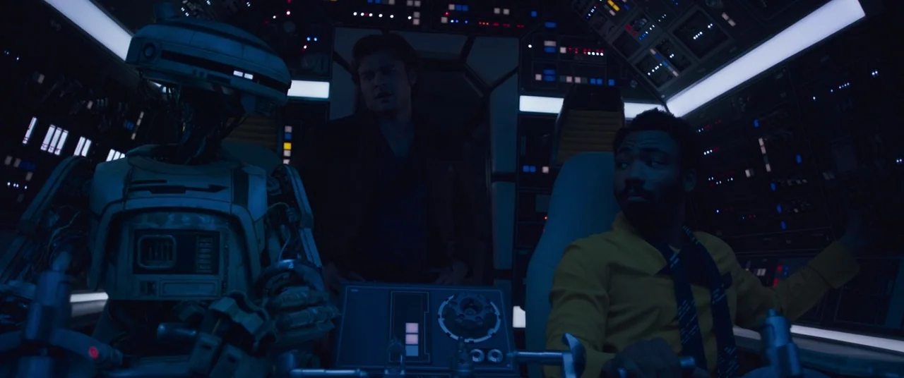 Solo: A Star Wars Story (2018) movie still: medium — The interior of a spacecraft cockpit features multiple glowing control panels in dark shadows.…