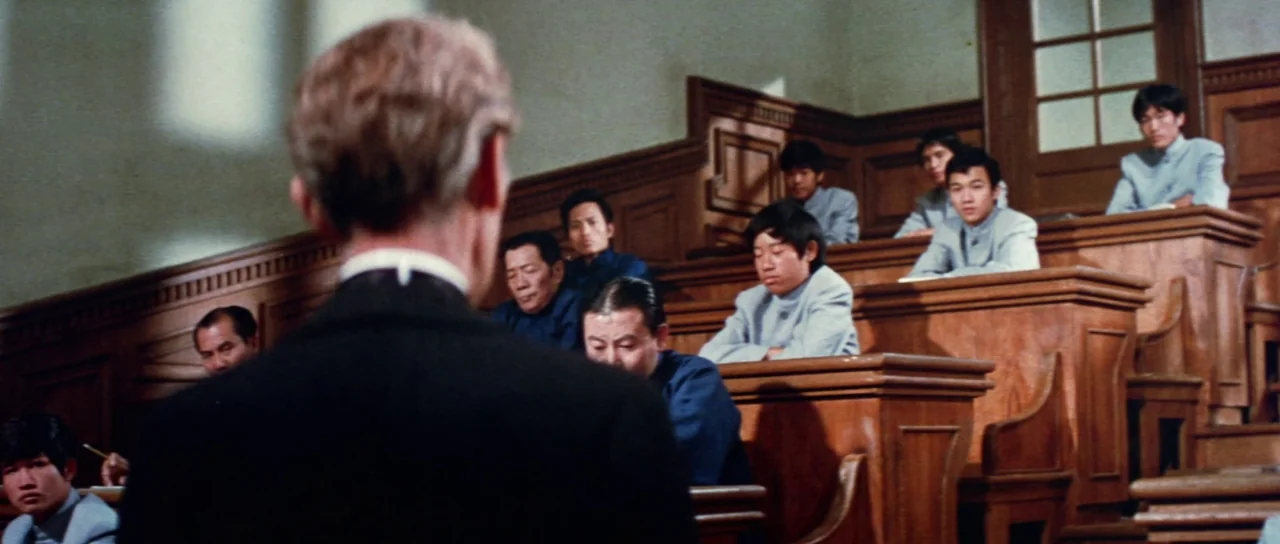 The Legend of the 7 Golden Vampires (1974) movie still: medium — An academic hall features tiers of wooden benches and ornate wood paneling. A group…