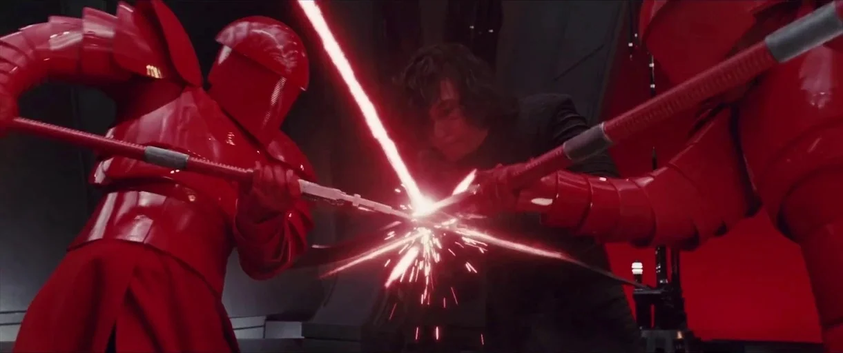 Star Wars: The Last Jedi (2017) movie still: medium — A dark futuristic interior features red-clad guards attacking a man with glowing weapons.…