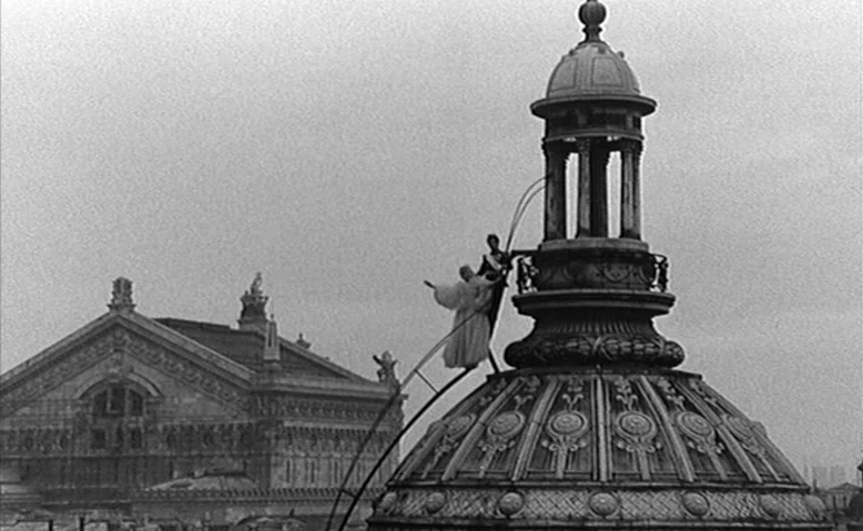 Who Are You, Polly Maggoo? (1966) movie still: wide — A person in robes balances on a curved ladder atop an ornate stone dome. A large neoclassical…