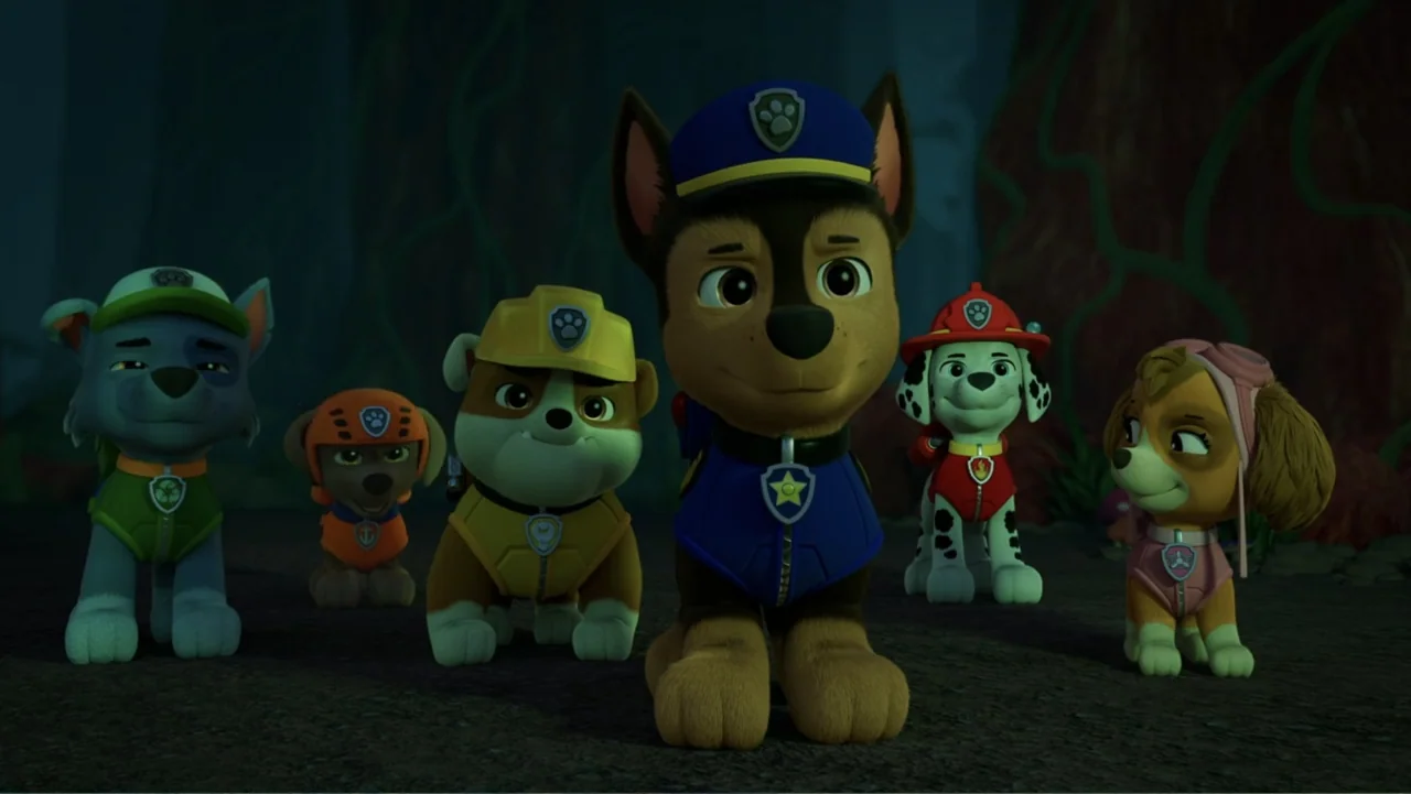 Valiente: A Tracker Story (2025) movie still: medium — Five cartoon puppies in uniform stand in a dark, cave-like environment with sparse…