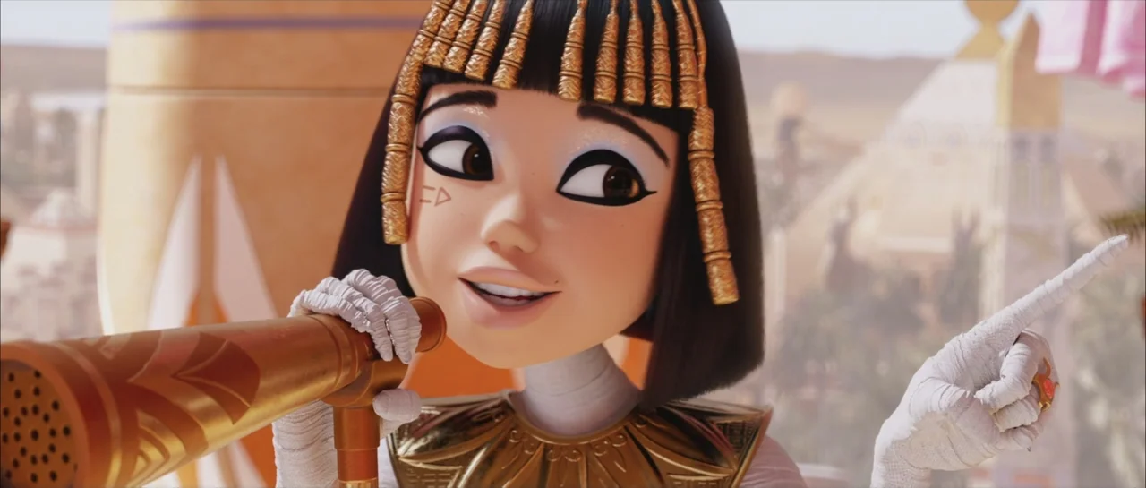 Mummies (2023) movie still: closeup — A bright exterior palace terrace features sand-colored architecture and blurry palm silhouettes. A young…