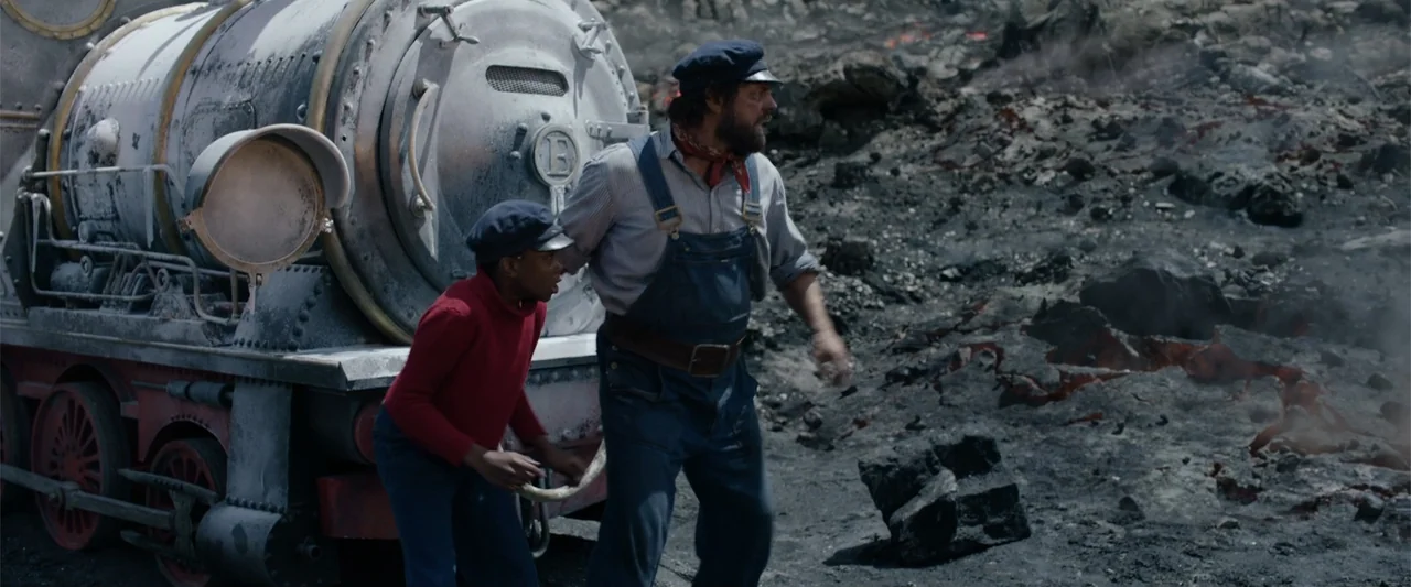 Jim Button and Luke the Engine Driver (2018) movie still: fullbody — A desolate volcanic landscape features jagged dark rocks and glowing molten…