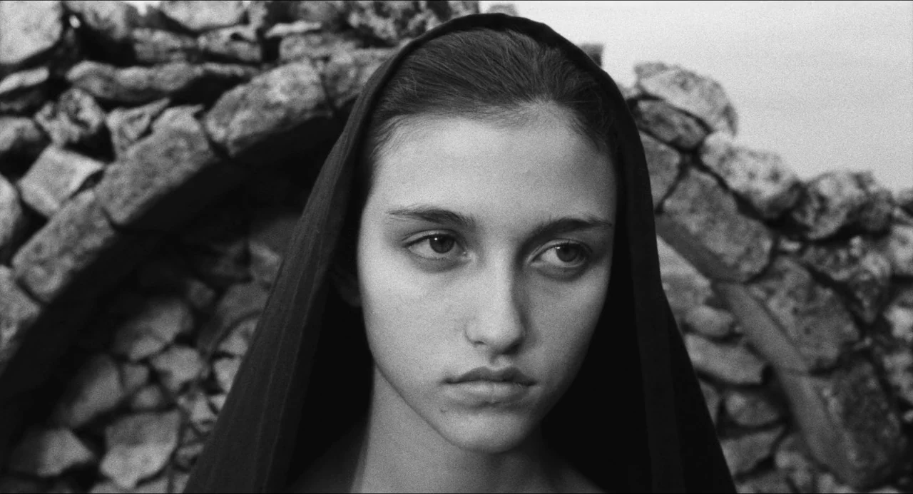 The Gospel According To St. Matthew (1964) movie still: closeup — The background consists of a curved wall built from stacked rough-hewn grey…