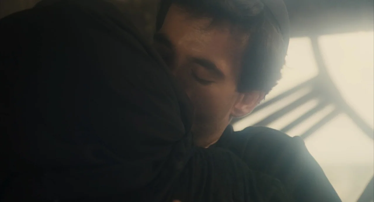 Camila (1984) movie still: closeup — Two individuals are embracing closely in a brightly lit indoor environment near a window. The man has his eyes…