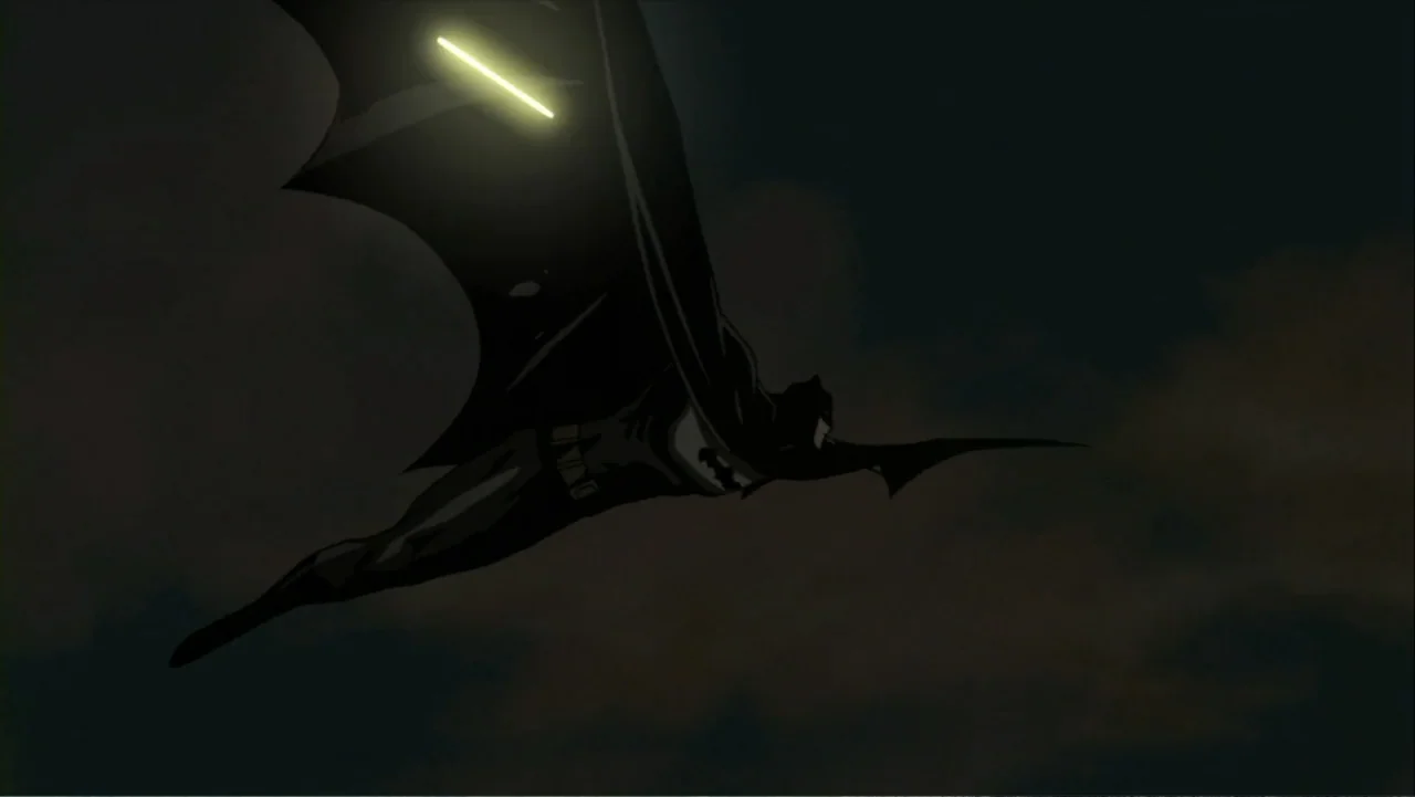 Batman: Gotham Knight (2008) movie still: fullbody — A dark, overcast night sky serves as the backdrop for a gliding figure. A costumed hero in a…