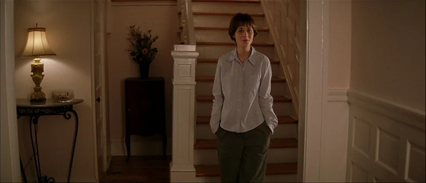 All The Real Girls (2003) movie still: medium — A residential foyer features white paneling, a wooden staircase, and a table lamp. A young woman…