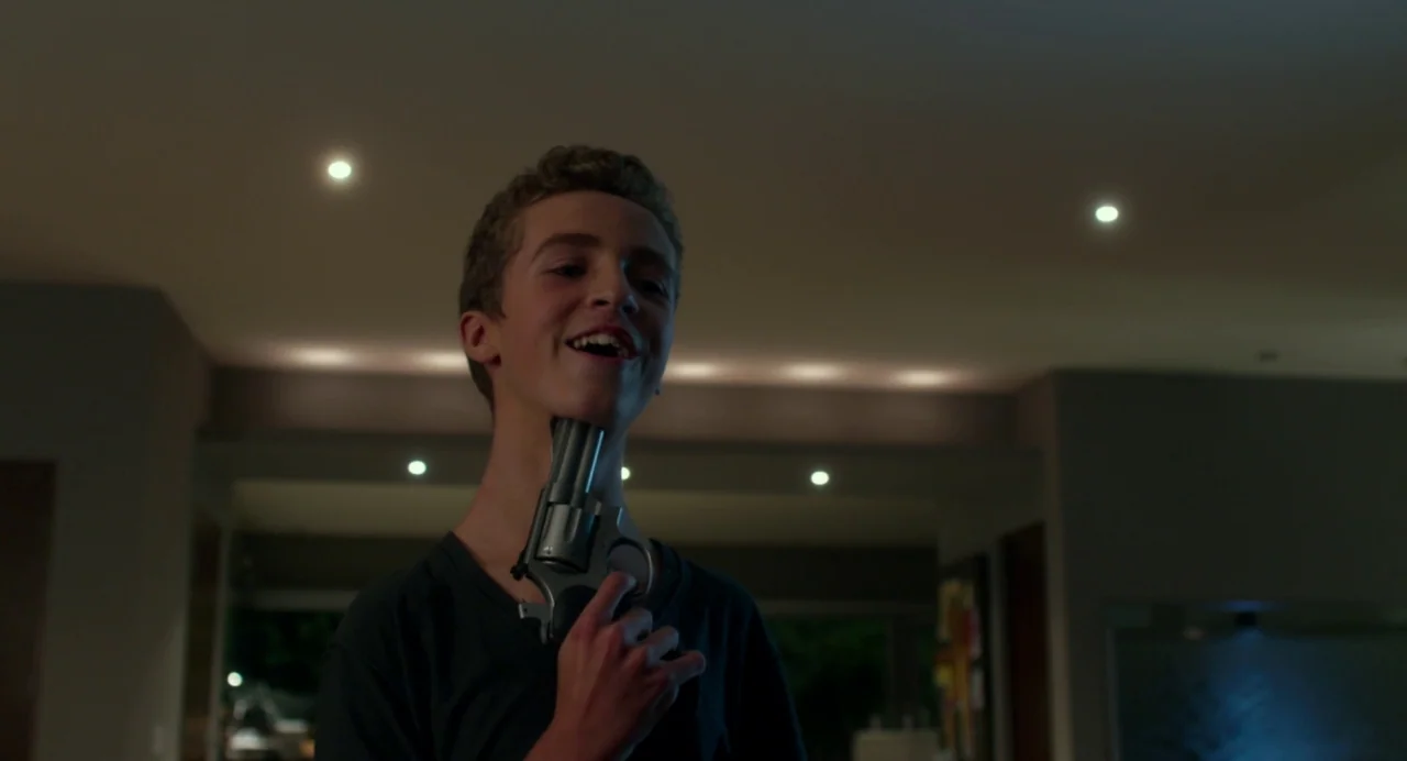 Maps to the Stars (2014) movie still: medium — A dimly lit modern home interior features recessed ceiling lights and soft shadows. A teenage boy…