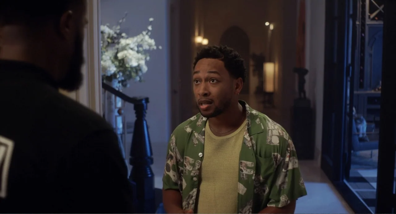 House Party (1990) movie still: medium — A residential hallway features a dark staircase with white walls and soft ambient light. A man in a…