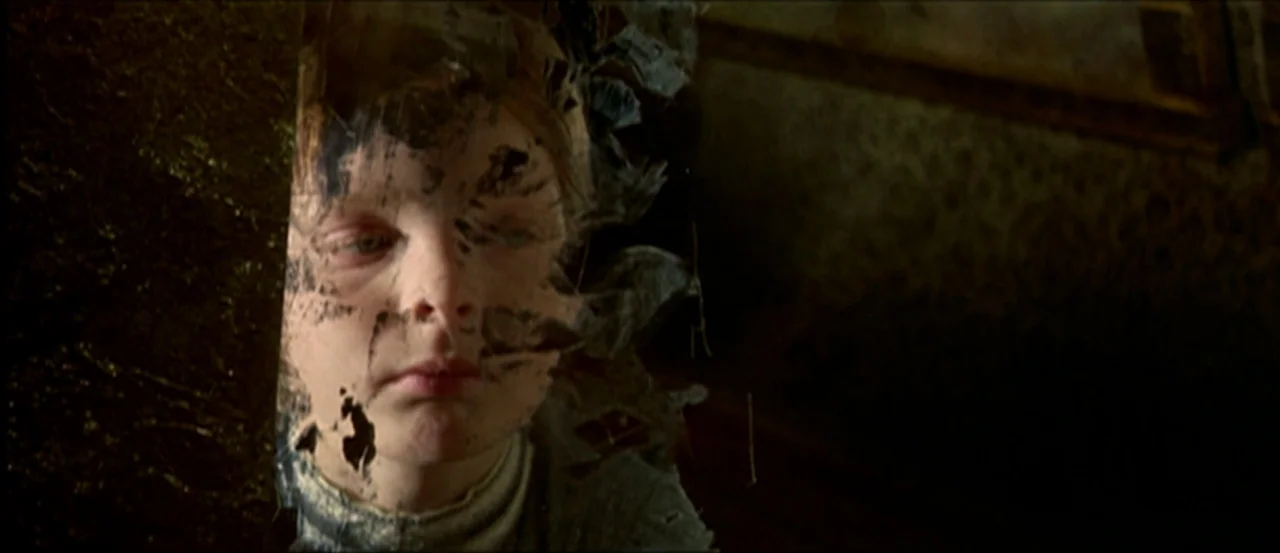 Flesh For Frankenstein (1973) movie still: closeup — A dimly lit interior space contains a child with a face distorted by pixels. The image glitch…
