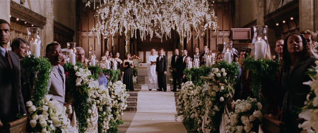 Spider-Man 2 (2004) movie still: wide — A stone-walled cathedral features wooden pews and massive hanging floral arrangements above the altar.…