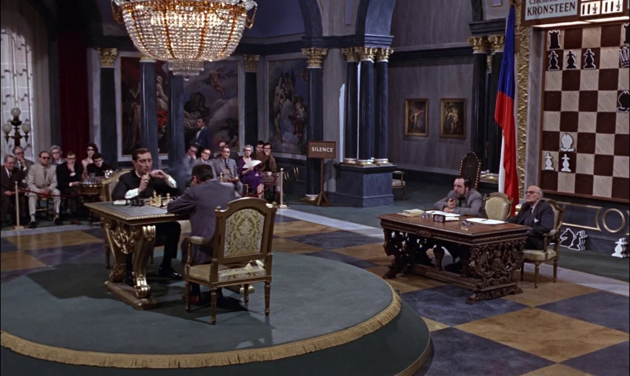 From Russia With Love (1963) movie still: wide — A grand tournament hall features a central raised platform with a chess match. Spectators sit in…