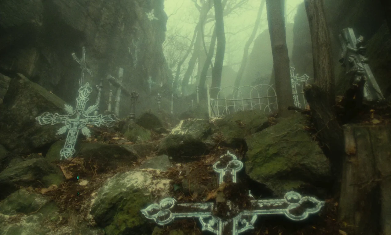 Litan (1982) movie still: establishing — A rocky, fog-laden cemetery path is filled with ornate metal crosses and stone rubble. Dead trees rise…