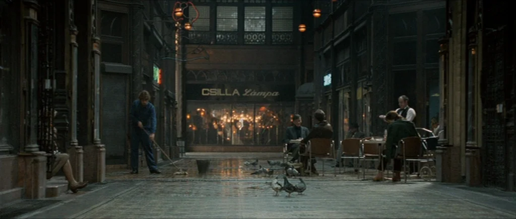 Tinker Tailor Soldier Spy (2011) movie still: wide — A historic, dark-toned shopping arcade features tiled floors and glass storefronts. Several…