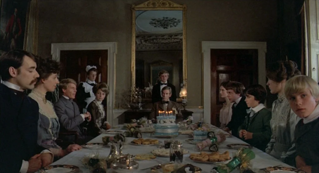 The Go-Between (1971) movie still: wide — An elegant, formal Edwardian-style dining room features tall mirrors and wood-paneled doors. A…